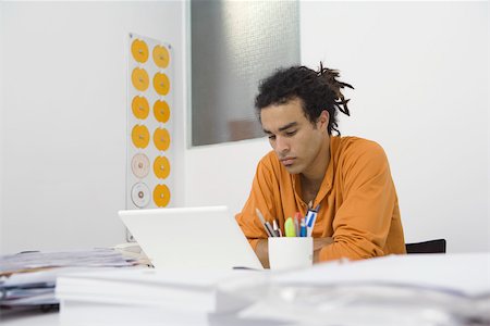 dreads - Man working at desk, arms folded Stock Photo - Premium Royalty-Free, Code: 632-02644905