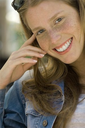 Young woman with freckles smiling at camera, portrait Stock Photo - Premium Royalty-Free, Code: 632-02645005