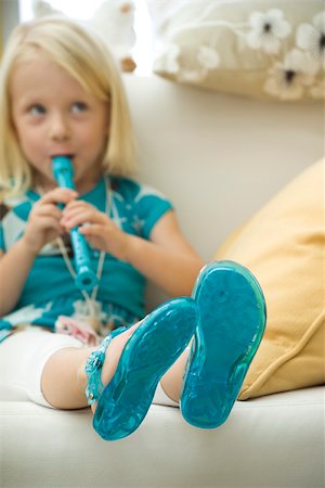 flauta dulce - Little girl sitting on sofa, playing recorder Foto de stock - Sin royalties Premium, Código: 632-02645120