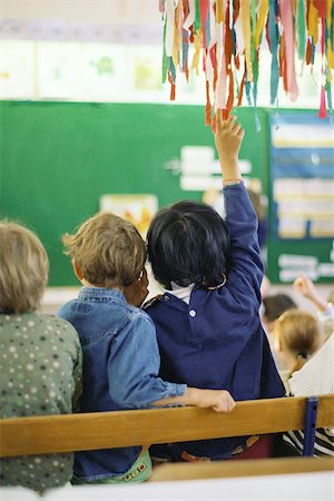 Child raising hand in class, rear view Stock Photo - Premium Royalty-Free, Code: 632-02690100