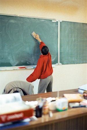 Boy erasing blackboard in classroom Stock Photo - Premium Royalty-Free, Code: 632-02690117