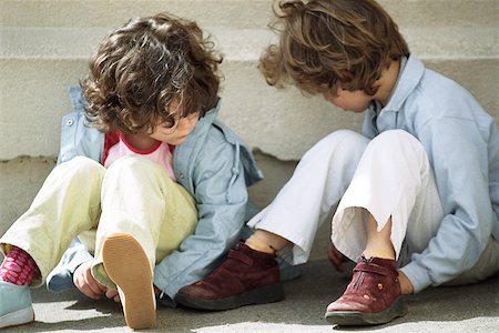 Two little girls sitting on ground and playing Foto de stock - Sin royalties Premium, Código: 632-02690125