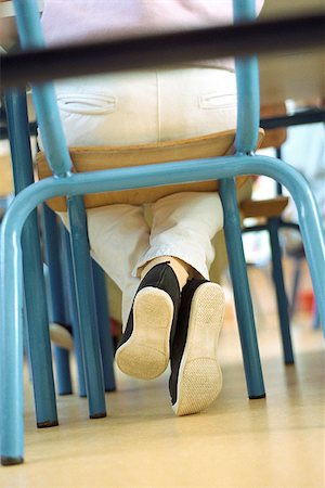 sole of shoe - Child sitting in chair, legs crossed at ankle, low angle view Stock Photo - Premium Royalty-Free, Code: 632-02690132