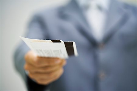 Man in suit holding out tickets Stock Photo - Premium Royalty-Free, Code: 632-02690214