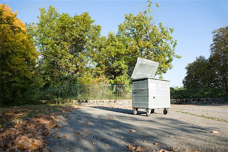 Small dumpster in parking lot at edge of wooded area Foto de stock - Sin royalties Premium, Código: 632-02690384