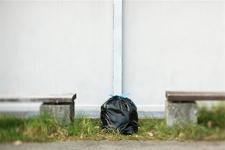 Garbage bag sitting on ground between two benches Stock Photo - Premium Royalty-Free, Code: 632-02690418