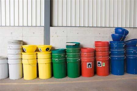 Multicolored garbage cans and recycling bins stacked along wall Stock Photo - Premium Royalty-Free, Code: 632-02690410