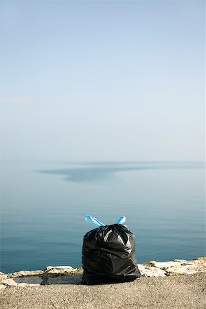 rubbish bag - Garbage bag on ledge with sea in background Stock Photo - Premium Royalty-Free, Code: 632-02690411