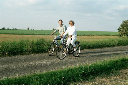 Deux vélos à travers la campagne, souriant à la caméra d'équitation Photographie de stock - Premium Libres de Droits, Code: 632-02744718