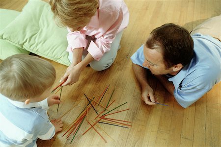 dad with toddler playing game - Family playing pick up sticks on floor Stock Photo - Premium Royalty-Free, Code: 632-02744743