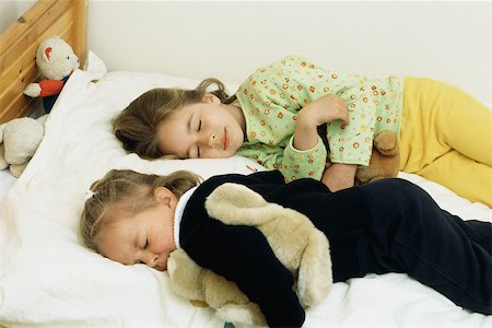 simsearch:640-06963758,k - Sisters sleeping in bed, cuddling stuffed animals Foto de stock - Royalty Free Premium, Número: 632-02744770