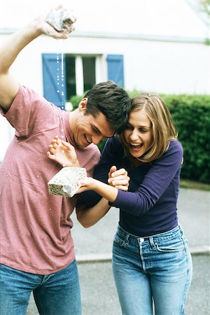 Homme serrant une éponge, femme riant, attraper l'eau avec une éponge Photographie de stock - Premium Libres de Droits, Code: 632-02744807