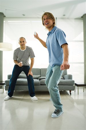 Two men playing video games with wireless controllers Stock Photo - Premium Royalty-Free, Code: 632-02744818