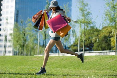 shoes shopaholic - Young woman running through park, carrying several shopping bags Stock Photo - Premium Royalty-Free, Code: 632-02744984