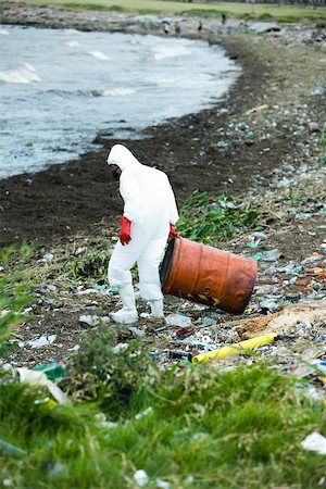 Person in protective suit removing hazardous waste from polluted landscape Foto de stock - Sin royalties Premium, Código: 632-02745049