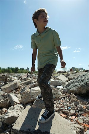 simsearch:649-06533602,k - Boy standing on heap of rubble, backlit Foto de stock - Royalty Free Premium, Número: 632-02745097