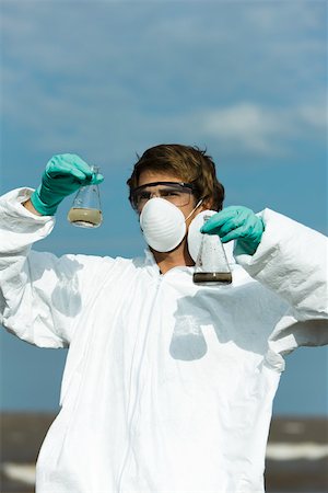 rifiuti tossici - Person in protective suit holding flasks filled with polluted water Fotografie stock - Premium Royalty-Free, Codice: 632-02745098