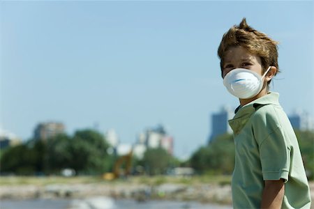 environmental pollution - Boy standing outdoors, wearing pollution mask Foto de stock - Sin royalties Premium, Código: 632-02745106