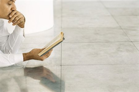 Senior man lying on tiled floor reading book Stock Photo - Premium Royalty-Free, Code: 632-02745114