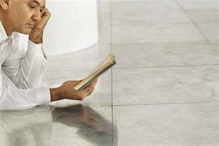 simsearch:632-05400916,k - Senior man lying on tiled floor reading book Foto de stock - Royalty Free Premium, Número: 632-02745139