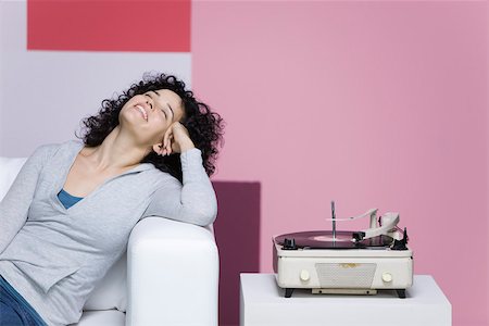 Woman enjoying music, listening to old-fashioned record player Fotografie stock - Premium Royalty-Free, Codice: 632-02745278