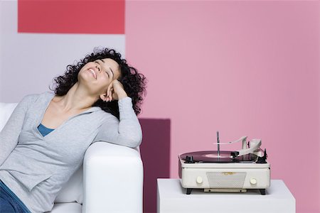 raro - Woman enjoying music, listening to old-fashioned record player Fotografie stock - Premium Royalty-Free, Codice: 632-02745278