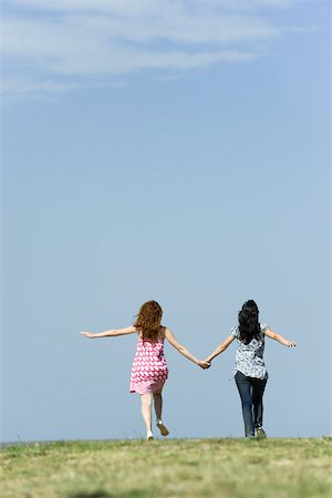 Deux jeunes femmes marchant main dans la main à l'extérieur, vue arrière Photographie de stock - Premium Libres de Droits, Code: 632-02885143