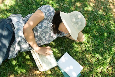 simsearch:695-03377942,k - Young woman lying on the ground reading, high angle view Stock Photo - Premium Royalty-Free, Code: 632-02885176