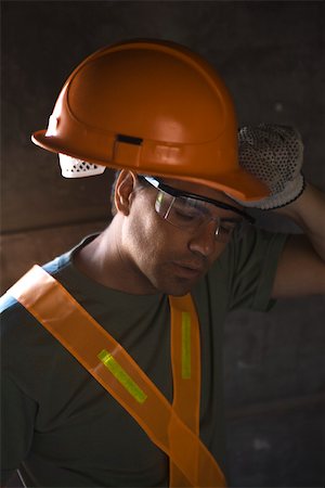 Construction worker taking hard hat off wiping brow with back of hand Foto de stock - Sin royalties Premium, Código: 632-02885334