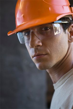 Construction worker wearing hard hat, protective glasses looking at camera Stock Photo - Premium Royalty-Free, Code: 632-02885347