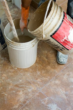 Worker pouring plaster from one bucket to another Stock Photo - Premium Royalty-Free, Code: 632-02885373