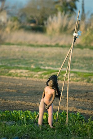 espantalho - Doll set against trellis in vegetable garden Foto de stock - Royalty Free Premium, Número: 632-02885509