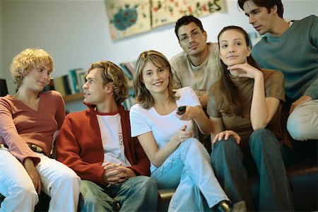 simsearch:632-03424709,k - Group of friends sitting close together on sofa watching TV Stock Photo - Premium Royalty-Free, Code: 632-03026780