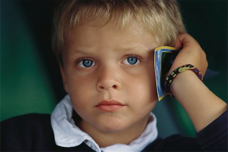 simsearch:632-05401219,k - Little boy holding card against head, sulking Fotografie stock - Premium Royalty-Free, Codice: 632-03027086