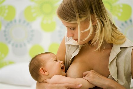 Young mother trying to breast feed crying baby Stock Photo - Premium Royalty-Free, Code: 632-03027274