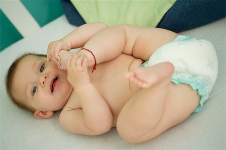 Baby lying on back, playing with foot Foto de stock - Sin royalties Premium, Código: 632-03027284