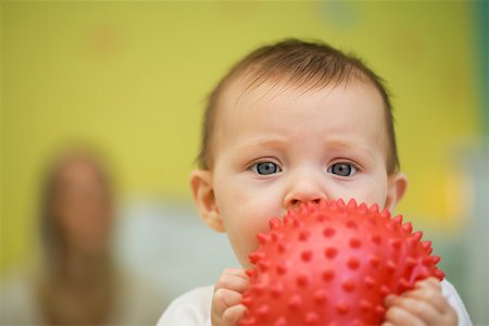 Baby holding toy in front of mouth Stock Photo - Premium Royalty-Free, Code: 632-03027303