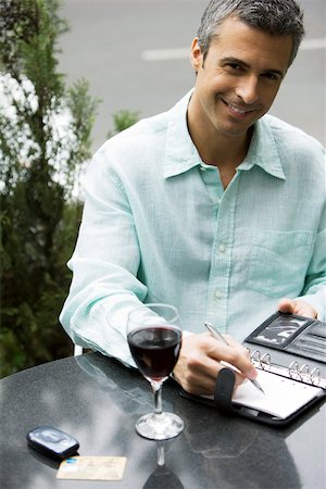 spain men cafe - Man sitting at outdoor cafe table with glass of wine, writing in agenda Stock Photo - Premium Royalty-Free, Code: 632-03027431