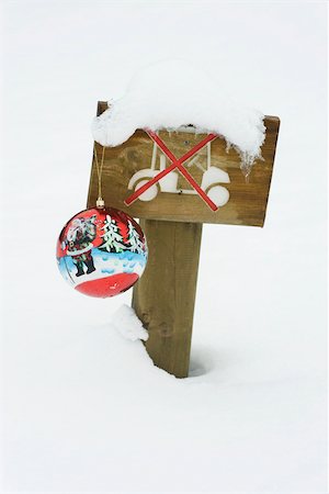 Decorative Christmas ornament hanging from snow-covered sign prohibiting driving golf cart in area Stock Photo - Premium Royalty-Free, Code: 632-03027586