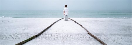 Boy standing at end of footpath on beach, looking at sea Foto de stock - Sin royalties Premium, Código: 632-03083012