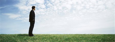 simsearch:614-01870270,k - Businessman standing in grassy filed with hands in pockets, looking at view Stock Photo - Premium Royalty-Free, Code: 632-03083053