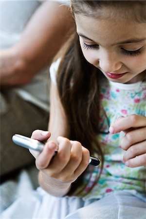 simsearch:632-03500989,k - Little girl looking at cell phone, woman in background Stock Photo - Premium Royalty-Free, Code: 632-03083198