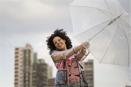 Young woman holding onto umbrella on windy day, laughing Foto de stock - Sin royalties Premium, Código: 632-03083428