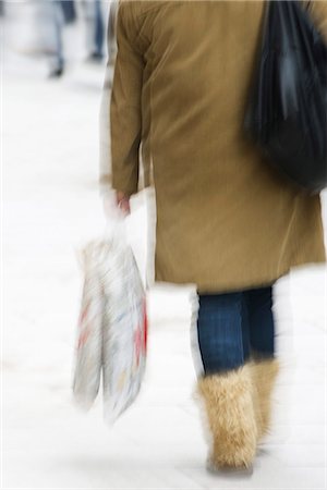 Pedestrian carrying shopping bags, rear view, blurred Stock Photo - Premium Royalty-Free, Code: 632-03083492