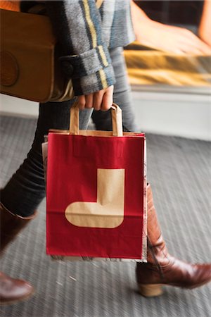 shopping christmas not holiday not fruit - Shopper carrying shopping bag with Christmas stocking on it, cropped Stock Photo - Premium Royalty-Free, Code: 632-03083501