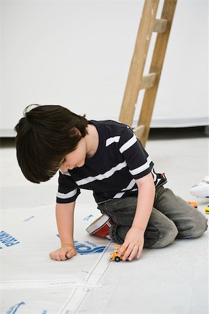 photo of boy sitting with his head down - Little boy playing with toy truck on floor Stock Photo - Premium Royalty-Free, Code: 632-03083550