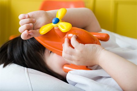 simsearch:632-05845347,k - Little boy covering face with toy helicopter Stock Photo - Premium Royalty-Free, Code: 632-03083611