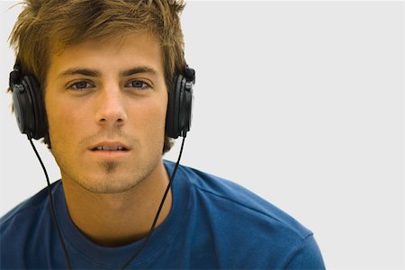 Young man listening to headphones Stock Photo - Premium Royalty-Free, Code: 632-03083643