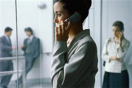 Businesswoman using cell phone in lobby, side view Stock Photo - Premium Royalty-Free, Code: 632-03193290