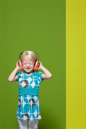 simsearch:632-03193343,k - Little girl with eyes closed wearing protective headphones Foto de stock - Royalty Free Premium, Número: 632-03193354